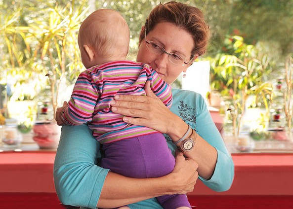 csm_asb-ehkind-pnierhoff2011-013_3fd8a64854.jpg Elternteil trägt Baby im Arm und hilft das Baby beim Atmen.